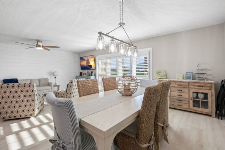 Open concept living and dining area with ceiling fan and flat screen TV in Indian Rocks Beach vacation rental
