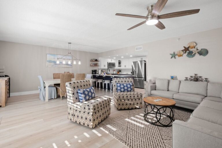 Spacious open living room with coastal decor ceiling fan and modern kitchen in Indian Rocks Beach vacation rental