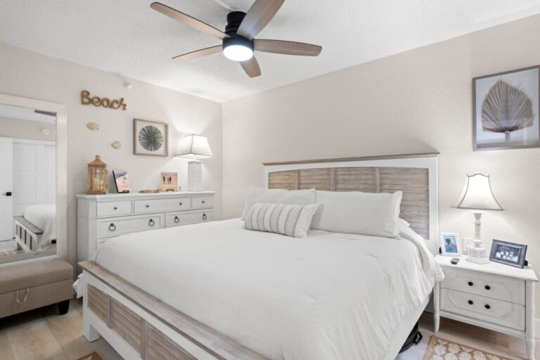 Master bedroom with king size bed coastal beach decor and ceiling fan in Indian Rocks Beach vacation condo