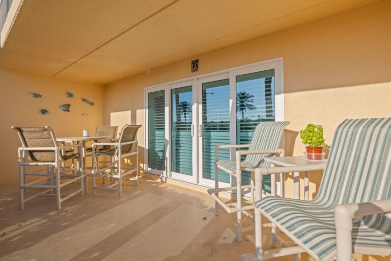 Private covered balcony with outdoor dining furniture and Intracoastal Waterway view at Indian Rocks Beach condo
