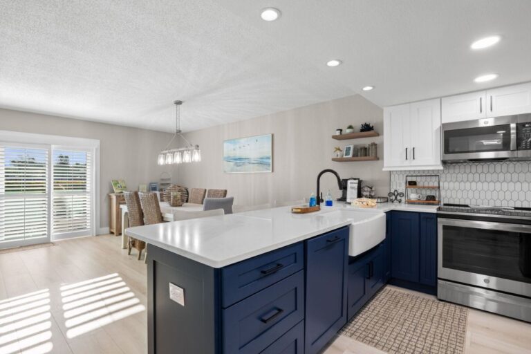 Open kitchen with farmhouse sink and dining area with plantation shutters overlooking Intracoastal Waterway